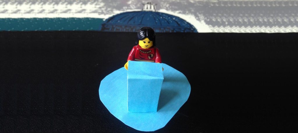 A lego figure with a concerned expression is standing against a blue podium
